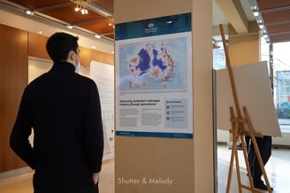 Ein Mann betrachtet ein Poster über Wasserstoffvorkommen in Australien.