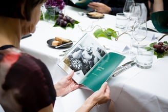 Ein Gast sieht sich beim Abendessen eine Broschüre über australische Weine an.