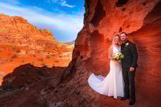 a bride and groom standing in a canyon