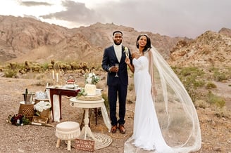 a man and woman standing in front of a desert