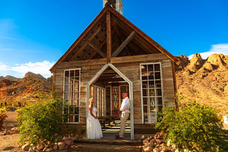 a bride and groom standing in front of a church