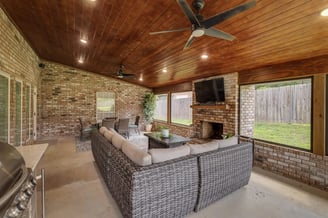 A photo of a screened patio with outdoor living and kitchen areas