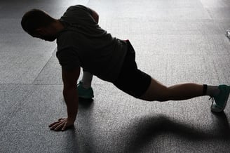 un homme fait du gainage et de l'activité physique au poids du corps