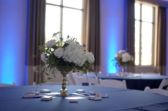 a table with a vase of flowers in a room with blue lighting