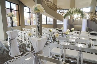 a wedding ceremony with white chairs and white chairs