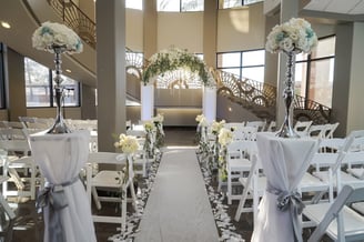 a wedding ceremony with white chairs and white chairs