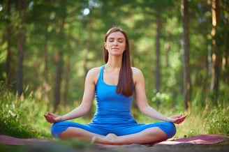 Woman in lotus pose in the park.