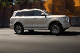 a silver suv driving down a street in the city