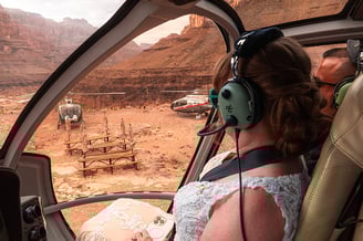 a woman in a white dress is sitting in a helicopter