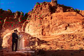 a bride and groom standing on a rocky cliff