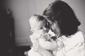 portrait en noir et blanc d’une maman tenant son bébé, moment doux et intime