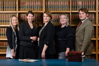 a group of people standing in front of a bookcase in a library