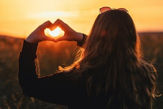 femme formant un coeur avec ses mains : plonger au coeur de soi