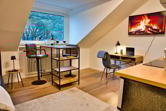 Business Apartment mit Schreibtisch, Hochtisch und Küche.