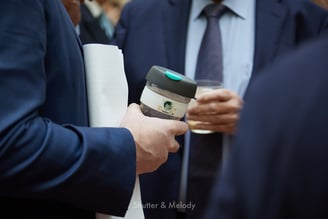Eine Kaffeetasse zum 70-jährigen Jubiläum in der Hand eines Gastes.