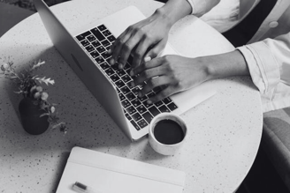 A person typing on a laptop | English to Portuguese translation, Spanish to Portuguese Translation