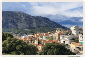 View of Archanes village with green landscapes, traditional old houses, and surrounding mountains
