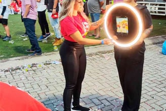 Uma mulher segurando totem de fotos móvel em um evento de marketing.