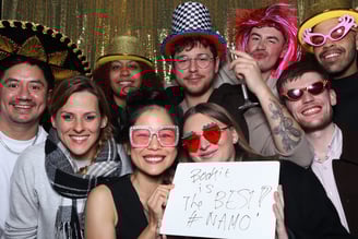 Guests at a corporate party posing for a picture with fancy dress props by Get The Picture
