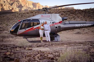 a man and woman standing in front of a helicopter