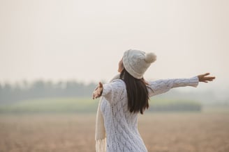 Happy woman enjoying in idyllic nature, celebrating freedom and rising her arms.