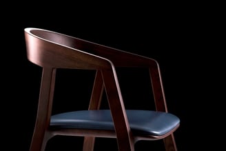 3D marketing design of a modern wooden chair with a detailed wooden frame, armrests, leather cushion