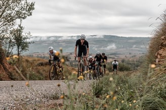 a group of cyclists riding down a road