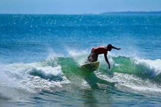 Um surfista na praia de Kuta, em Bali - Por Jordy Meow (Wikipédia)