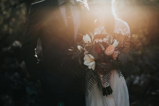 a bride and groom standing in front of a sunlit sunlit background
