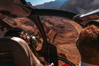 a man in a suit and tie is looking out over a mountain