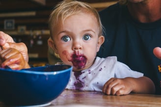 a baby eating a bowl of food