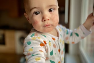 a baby is standing in front of a window