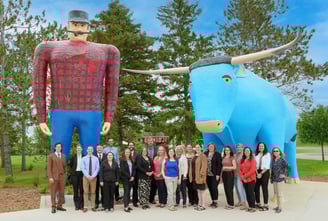 a group of people standing in front of Paul & Babe in Bemidji
