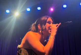 LuxeBand singer performing on stage at a corporate event