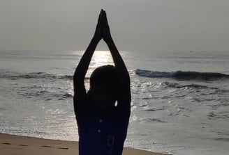 a person doing yoga on a beach