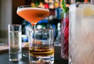 Photo d'une sélection de cocktails variés sur un bar dans une ambiance de bar chic et colorée