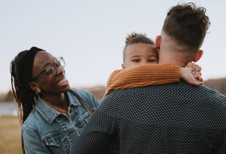 Family in field smiling with child