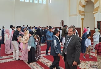 a group of people standing in The Imam Malik Mosque