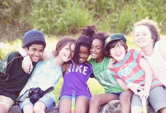 a group of children sitting on a bench in a park