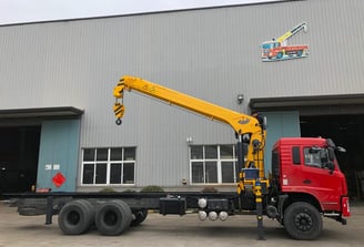 Yellow SQS300A-4 truck-mounted telescopic crane with robust boom, outdoors, ideal for heavy lifting.