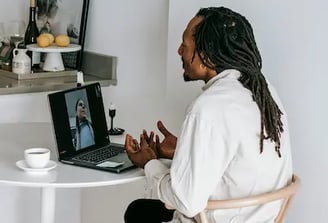 Homem sentado olhando para o computador conversando por video chamada
