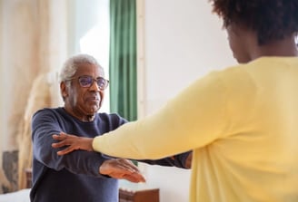 An older man and woman are joyfully dancing together, showcasing their connection and enjoyment of t