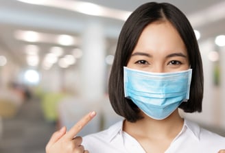 a woman in a white shirt and a blue mask mask