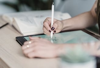 Personne dessinant sur sa tablette avec un stylet