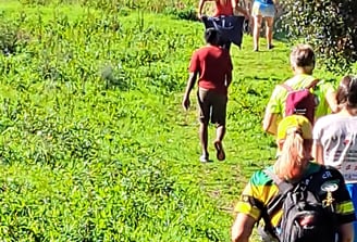 people climbing a grassy trail