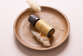 a bottle of essential oils on a plate with a feather feather