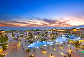 a beautiful hotel resort with a large pool with a view of the ocean