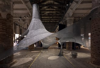 Modern architectural installation in an industrial-style exhibition space.