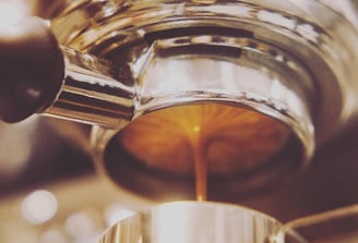 a naked portafilter is extracting a double shot of espresso