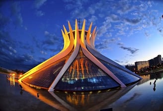 Catedral Metropolitana de Brasília iluminada pelo sol ao final do dia com céu azul ao fundo